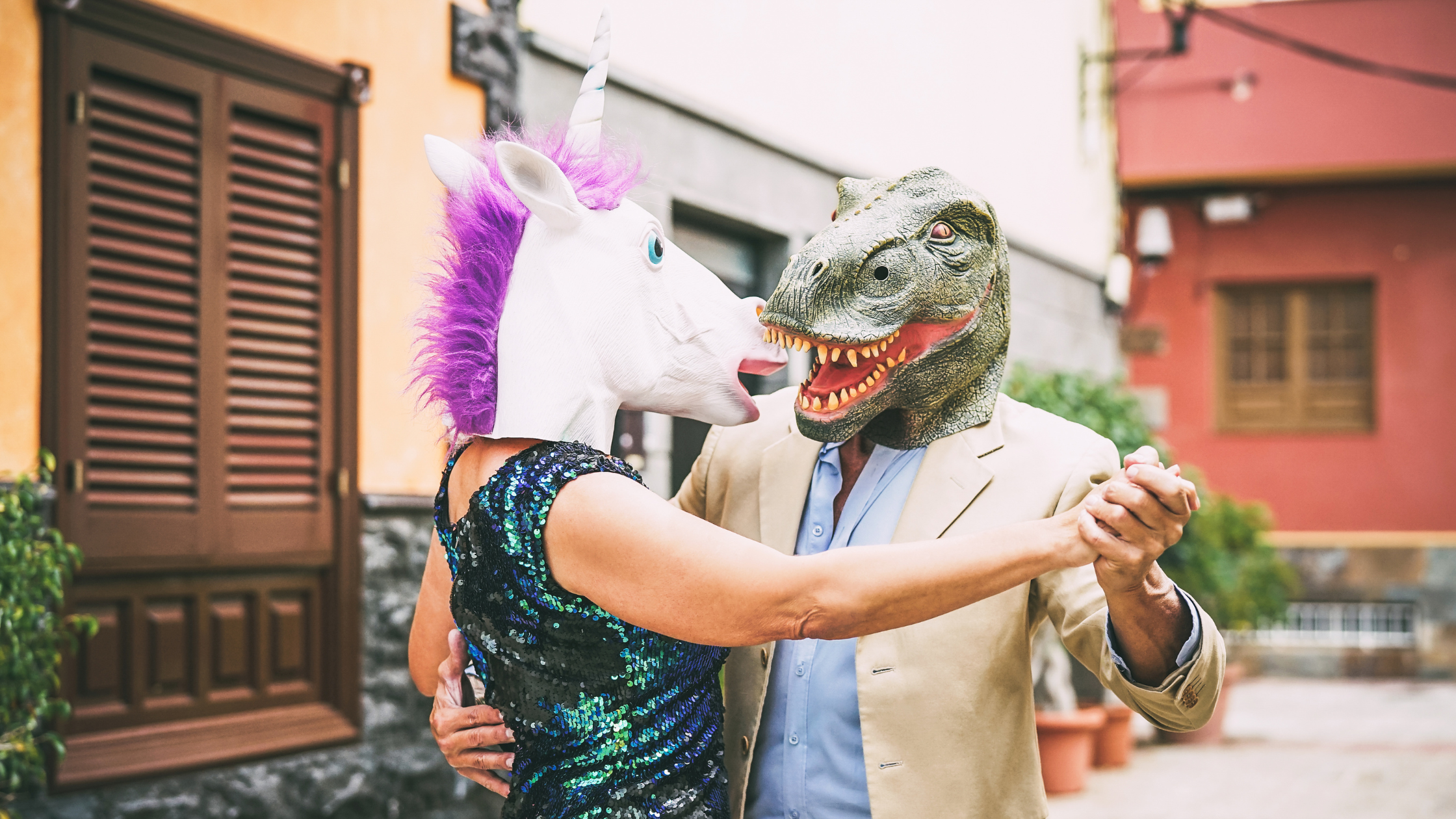 Couple dancing in Halloween dinosaur masks